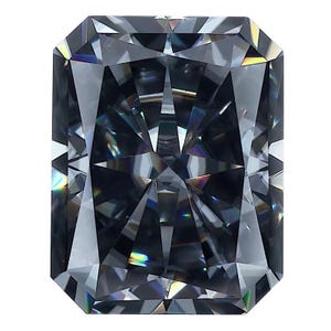 May include: A radiant-cut, gray gemstone with a rectangular shape. The facets of the stone reflect light, creating a sparkling effect. The gemstone is set against a white background, highlighting its clarity and brilliance.