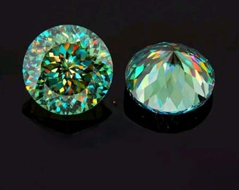 May include: Two round, faceted gemstones with a teal hue and rainbow iridescence. The gems are set against a black background, showcasing their brilliance and clarity. The gemstones are likely for jewelry making.