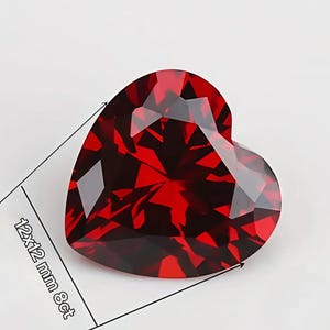 May include: A heart-shaped, deep red faceted gemstone with a brilliant cut. The stone is labeled with dimensions of 12x12 mm and a weight of 8ct, indicated by black lines and text on the side of the gem, showing its precise size and weight.