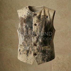 May include: A tan and brown cowhide vest with a button-up front and two front pockets. The vest has a round collar and the text "CANEBOUND LEATHER GOODS" is visible on the front.