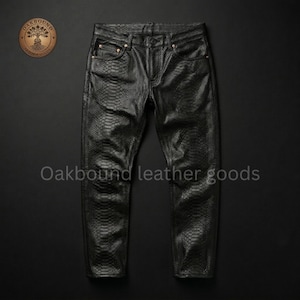 May include: Black leather trousers with a snakeskin pattern. The trousers feature a traditional five-pocket design with a button and zip fastening. The text "Oakbound leather goods" is visible at the bottom of the image.