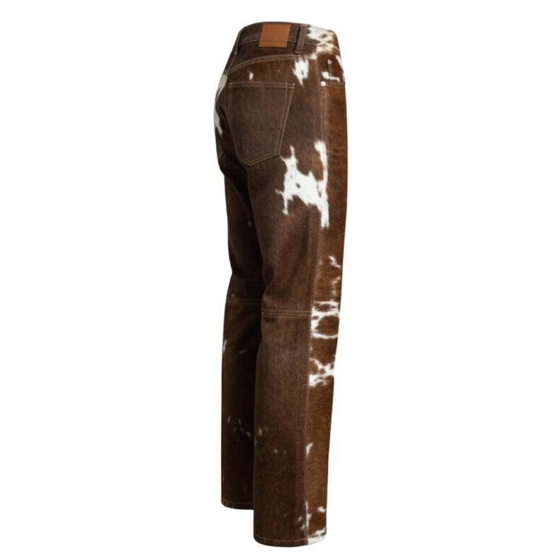 May include: Brown and white cowhide-patterned jeans. The jeans have a classic five-pocket design with a brown leather patch on the back. The pants are made of a durable material and have a straight leg cut.