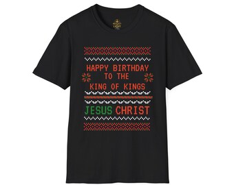 Può includere: T-shirt nero con un design festivo. Il design include il testo "HAPPY BIRTHDAY TO THE KING OF KINGS JESUS CHRIST" in rosso e verde, con elementi decorativi. La maglietta è realizzata in un materiale morbido.