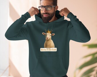 Può includere: Felpa con cappuccio verde scuro con una grafica di un agnello con una corona d'oro. La grafica dell'agnello è centrata sul petto, con la scritta "Worthy Is The Lamb" sotto. La felpa ha una tasca frontale e un cappuccio.