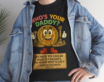 May include: Black t-shirt with a colourful graphic. It features a smiling coin character and the text "WHO'S YOUR DADDY?" along with a quote from Jesus of Nazareth. The design has a vintage, cartoon style.