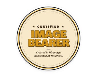 May include: A circular sticker with a cream-coloured background and a black and gold border. The text reads CERTIFIED IMAGE BEARER in bold gold letters, followed by the smaller black text: Created in His image. Redeemed by His blood.