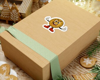 May include: A rectangular cardboard gift box wrapped with a light green ribbon, featuring a sticker of a cartoon gold coin character with a smiling face, large eyes, white gloves, and red boots, giving a thumbs-up gesture with both hands.