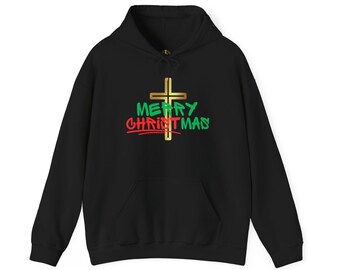 Può includere: Felpa con cappuccio nera con tasca frontale. Il design presenta una croce dorata con le parole "MERRY CHRISTMAS" in verde e rosso. La felpa è realizzata in un materiale morbido.
