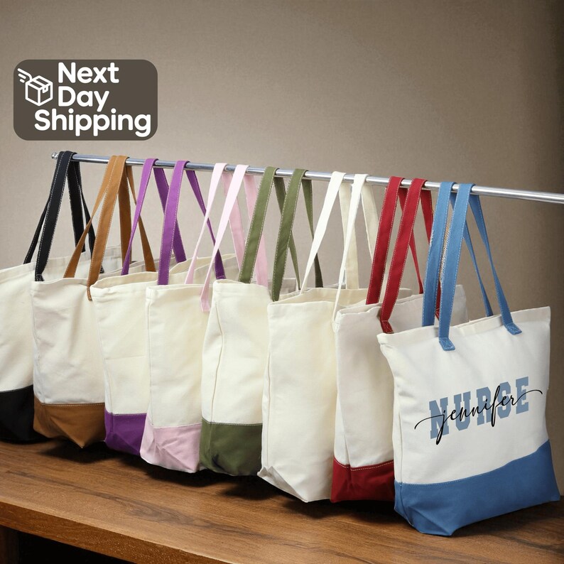 A row of colorful tote bags with various patterns and colors, including white, blue, and red, hanging on a rack.
