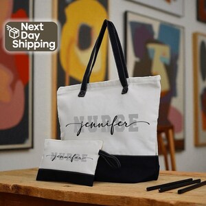 A tote bag with the name "Jennifer" printed on it, along with a smaller bag that also has the name "Jennifer" printed on it. The bags are placed on a wooden surface, and there are some artworks visible in the background.