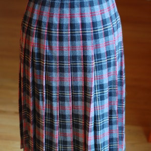 May include: A pleated skirt with a plaid pattern in shades of blue, black, red, and yellow.