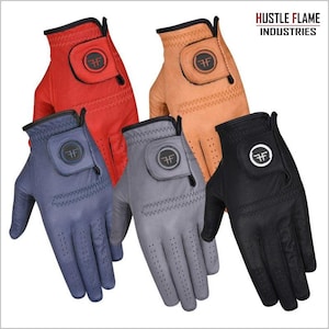 Puede incluir: Una colección de cinco guantes de golf en varios colores: rojo, beige, azul, gris y negro. Cada guante presenta un emblema circular con las letras "FF" y está perforado para mayor transpirabilidad. Los guantes están diseñados para uso deportivo.