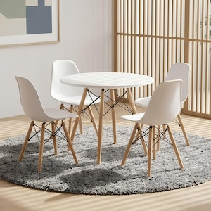 May include: A round white dining table with four matching white chairs, each featuring molded seats and light-toned wooden legs connected by a black metal cross-brace structure, arranged around a circular gray textured area rug.