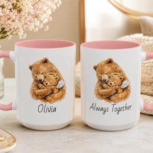 Pink handle pregnancy loss memorial mug with watercolor bear holding angel baby bear, personalized with Olivia and Always Together, styled on a soft neutral bedside table.