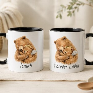 Black handle baby loss memorial mug set with watercolor angel baby bear design, personalized with Isaiah and Forever Loved, styled on a warm neutral tabletop.