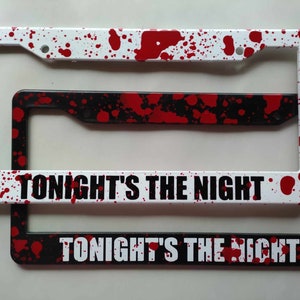 May include: Two white and black license plate frames with a red splatter paint design. The frames have the text "Tonight's The Night" printed in white.
