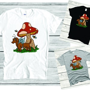 May include: White, grey, and black t-shirts with a cartoon image of a dachshund wearing a snail shell on its back and standing under a red and white mushroom.  There are bees flying around the mushroom.