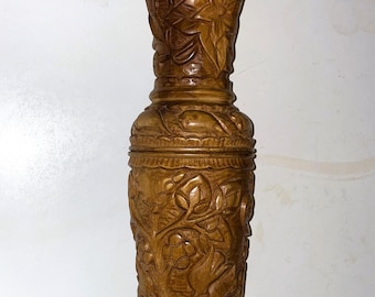 Jarrón vintage de madera tallada a mano con flores.