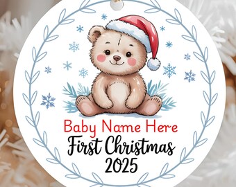 May include: A round Christmas ornament featuring a cartoon bear wearing a Santa hat. The ornament has the text "Baby Name Here First Christmas 2025" in red and black. The ornament is hanging on a string.