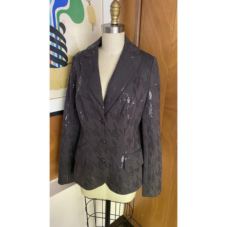 K&ouml;nnte beinhalten: Ein schwarzer Blazer mit Pailletten, Knopfleiste und langen &Auml;rmeln.