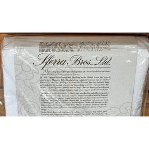 Pu&ograve; includere: Una confezione di biancheria di lusso Sferra Bros. Ltd. La confezione presenta il logo dell'azienda e una descrizione della storia del marchio, evidenziando le sue radici italiane e l'impegno per la qualit&agrave; e il design.