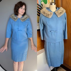 Puede incluir: Un traje de falda azul claro vintage con una chaqueta a juego con cuello de piel y un lazo en la cintura. La falda llega a la rodilla. La chaqueta tiene mangas tres cuartos. El traje se muestra en un maniquí y lo lleva una persona.