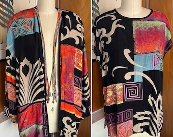 May include: Two-piece vintage clothing set. The set includes a black kimono-style jacket and a short-sleeved top. Both pieces feature a vibrant, geometric pattern with red, blue, and beige accents. The jacket is open-fronted, and the top has a round neckline.