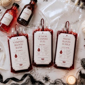 May include: Three clear plastic drink pouches filled with red liquid, each featuring a white label with text including Vampire Blood Bank, Junior Vampire Fuel, and Fresh Blood Supply, alongside two glass bottles labeled Grenadine and Cherry Juice.