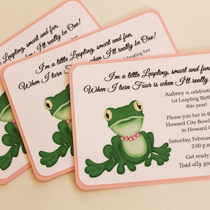 Puede incluir: Una invitación rosa y blanca con una ilustración de rana verde. La invitación dice "Soy una pequeña Leapling, inteligente y divertida, Cuando cumpla cuatro años, realmente seré una!" e incluye detalles para la fiesta de cumpleaños de 1er Leapling de Aubrey.