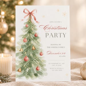 Watercolor Christmas tree party invitation card with red bow and gold bells, displayed against a lit Christmas tree background