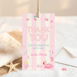 Op de afbeelding: Een rechthoekig cadeaulabel met verticale roze en crèmekleurige strepen, voorzien van de tekst THANK YOU FOR CELEBRATING WITH ME! Love, Olivia. Het ontwerp bevat illustraties van een strandbal, camera, zeester, slippers, ijsje, badpak, parasol, zonnebrandcrème, zonnebril en een flamingo zwemband.
