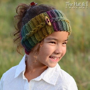 May include: A young girl wearing a colourful crocheted headband with a wooden button. The headband has a cable knit pattern and is made with shades of green, purple and brown yarn.