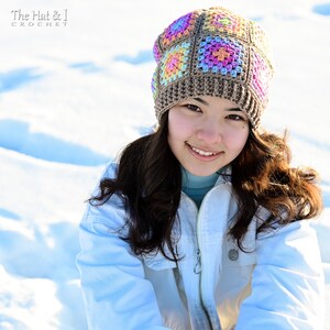 Puede incluir: Un gorro de ganchillo colorido con un patr&oacute;n cuadrado en tonos marr&oacute;n, rosa, amarillo y azul. El gorro lo lleva una persona con una chaqueta azul claro. El texto "The Hat & I Crochet" es visible.