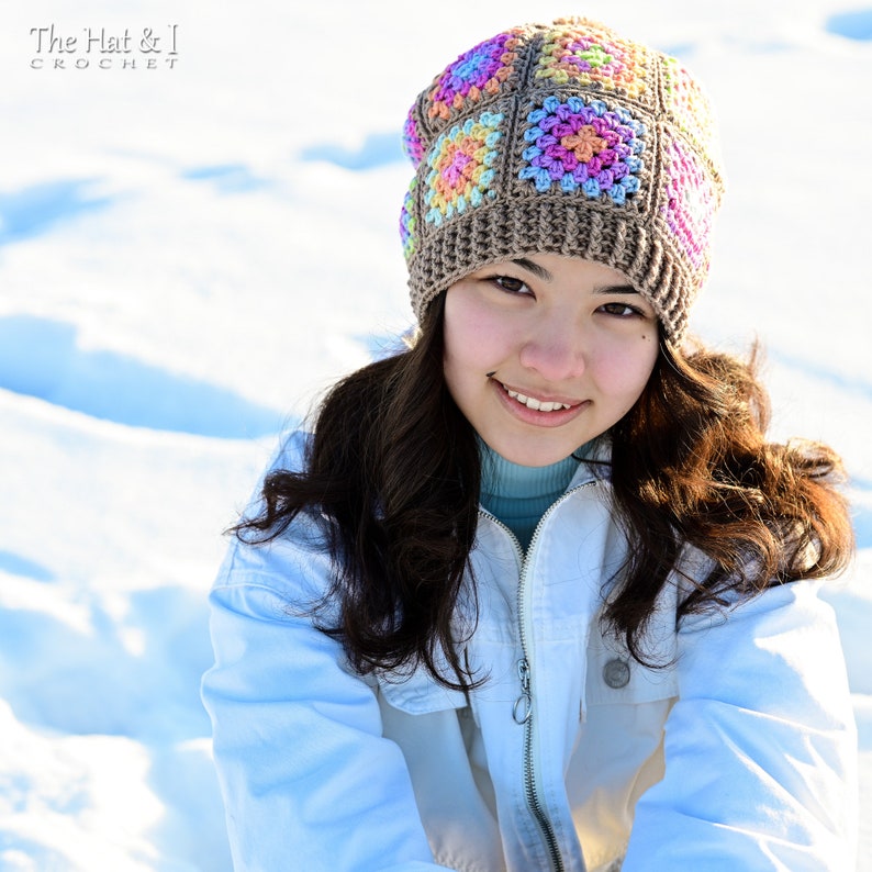 Puede incluir: Un gorro de ganchillo colorido con un patr&oacute;n cuadrado en tonos marr&oacute;n, rosa, amarillo y azul. El gorro lo lleva una persona con una chaqueta azul claro. El texto "The Hat & I Crochet" es visible.