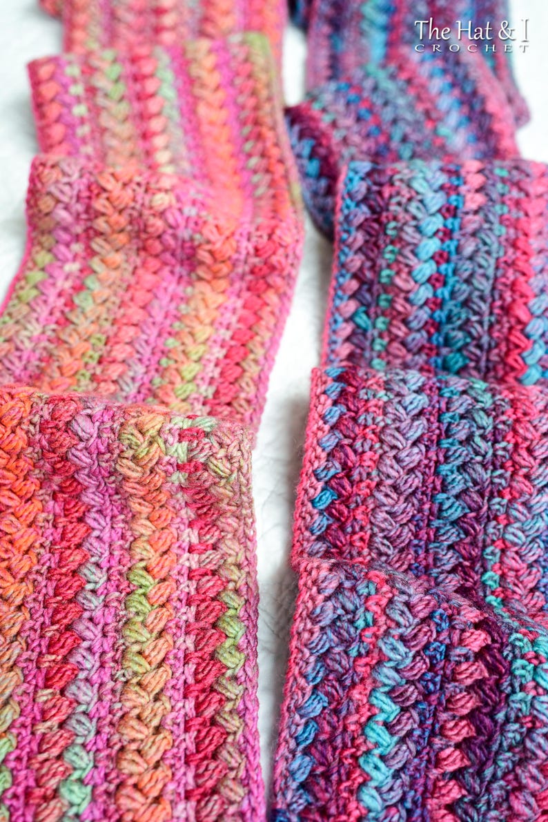 Pu&ograve; includere: Due sciarpe all'uncinetto in filato multicolore con sfumature di rosa, blu e verde. Le sciarpe sono realizzate con un punto a trama.