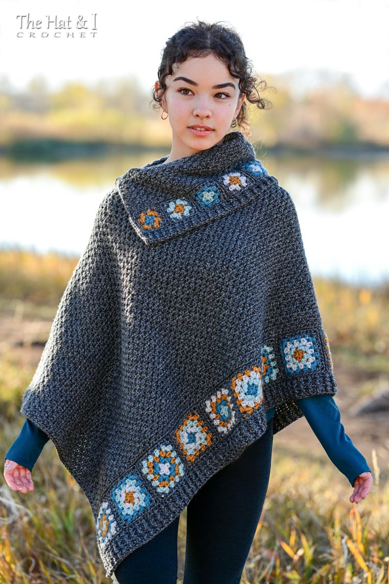 May include: A gray crochet poncho with a cowl neck and floral border. The poncho features a repeating pattern of square floral motifs in shades of orange, blue, and white. The text "The Hat & I Crochet" is at the top.