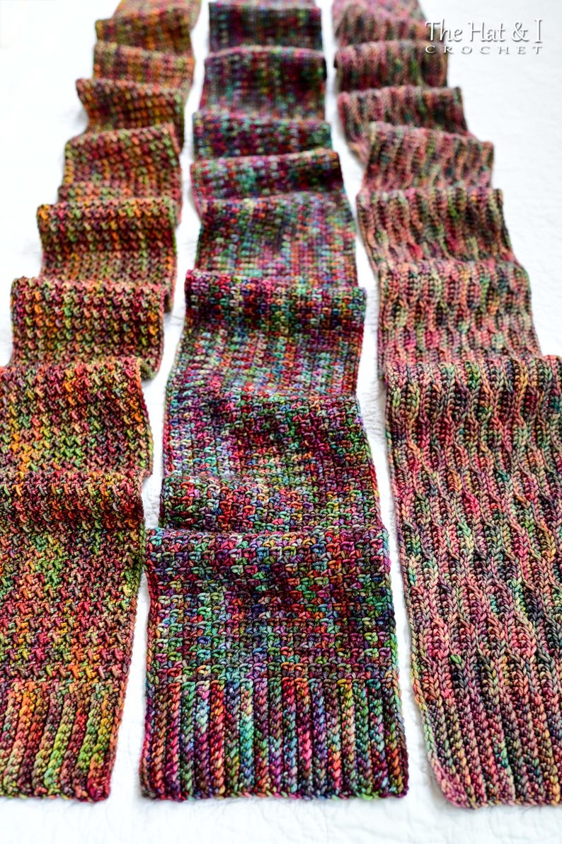 May include: Several hand-crocheted scarves in various patterns and colors are displayed on a white surface. The scarves feature a mix of vibrant hues, including red, green, purple, and orange. The image showcases the texture and detail of the handmade items.