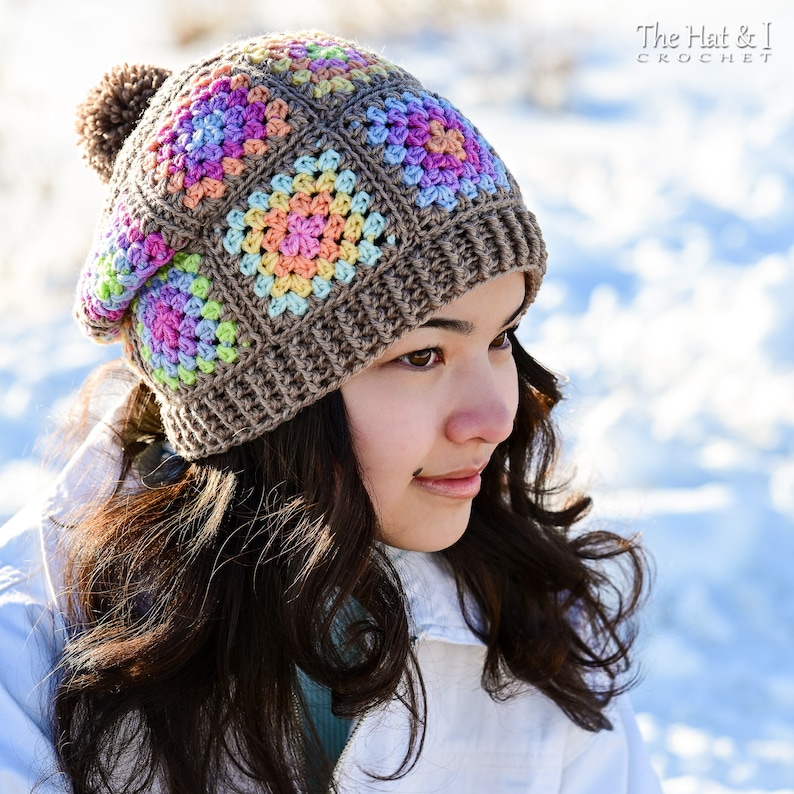 Puede incluir: Un gorro de ganchillo marr&oacute;n con un dise&ntilde;o de cuadrados coloridos. El gorro presenta cuadrados en tonos rosa, amarillo, azul y verde. Una borla marr&oacute;n est&aacute; unida a la parte superior. El texto "The Hat & I Crochet" est&aacute; en la esquina superior derecha.
