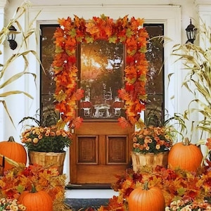 Peut inclure: Une porte d'entrée décorée sur le thème de l'automne avec des citrouilles orange, des feuilles d'automne et des chrysanthèmes en pot. Une guirlande de feuilles d'automne encadre la porte. La porte est en bois.