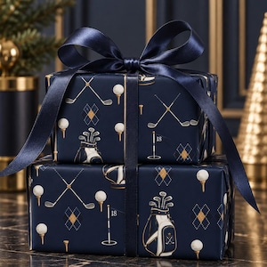 May include: Two rectangular gift boxes stacked vertically, wrapped in dark navy blue paper featuring a repeating golf-themed pattern of clubs, balls on tees, golf bags, and argyle diamonds, tied together with a wide, dark navy satin ribbon bow.