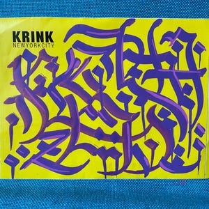 Peut inclure: Un autocollant rectangulaire jaune orné d'une calligraphie violette de style graffiti au centre. Le texte KRINK NEWYORKCITY est imprimé en noir dans le coin supérieur gauche. Le motif se compose de traits de pinceau violets fluides.
