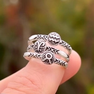 May include: Three silver rings with zodiac symbols. The rings are stacked on top of each other. The top ring has an Aquarius symbol, the middle ring has an Aries symbol, and the bottom ring has a Cancer symbol.