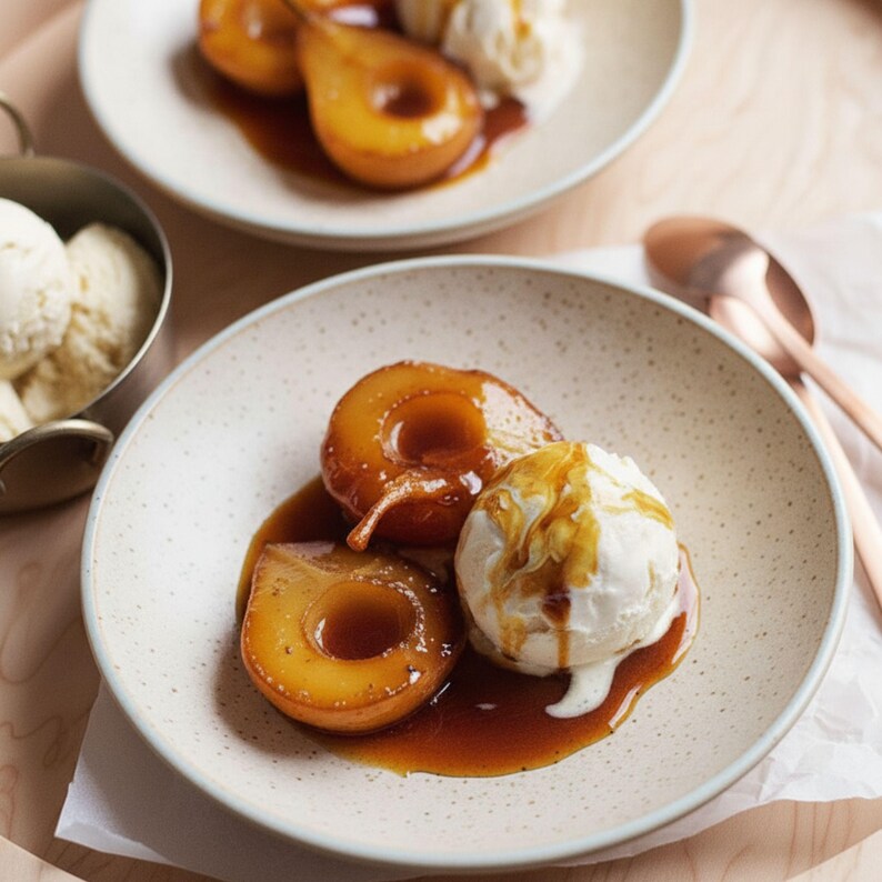May include: A plate of poached pears with a scoop of vanilla ice cream, drizzled with caramel sauce. The pears are golden brown and sit in a pool of sauce. The ice cream is white and creamy.