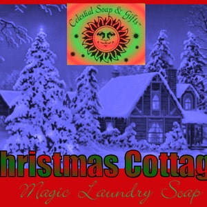 May include: A snowy winter scene with a cottage in the background. The text "Christmas Cottage" is in red, green, and black letters. The text "Magic Laundry Soap" is in green letters. The image is for a Christmas-themed laundry soap.