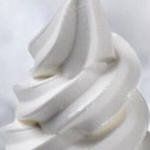 May include: Close-up of a white soft-serve ice cream cone.