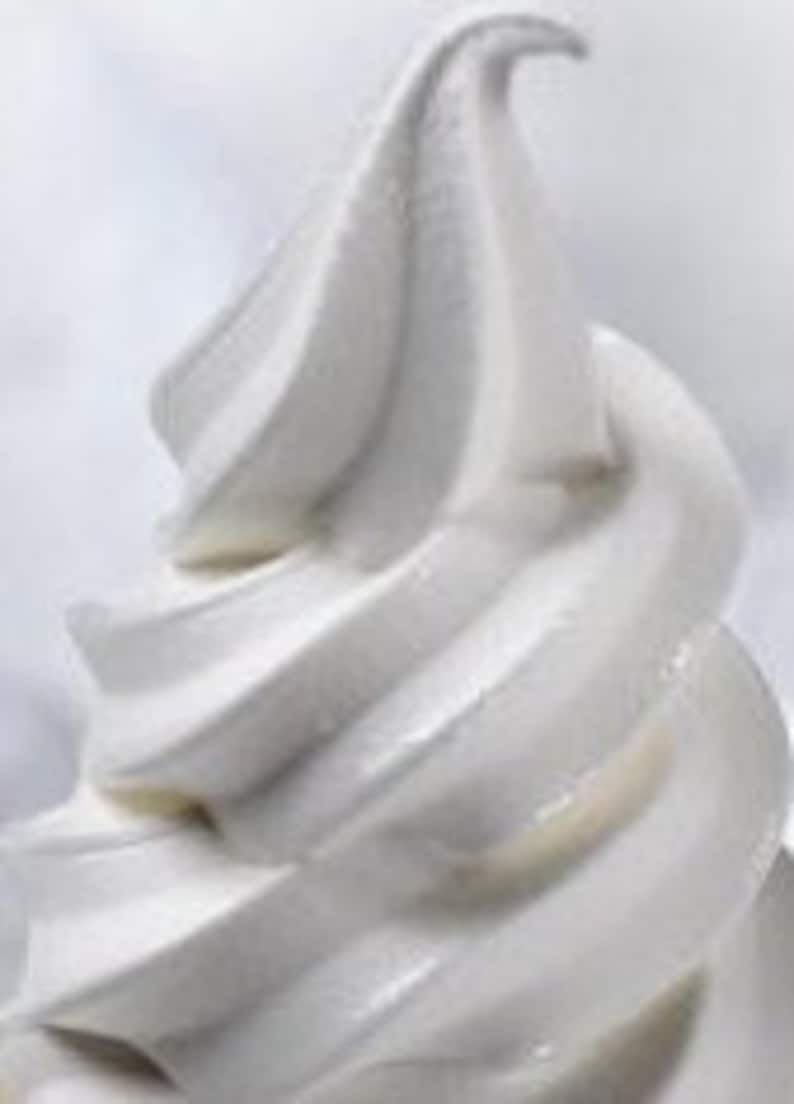 May include: Close-up of a white soft-serve ice cream cone.
