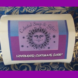 May include: A white rectangular soap bar with a purple, blue, and pink label. The label features a sun with a face and the text "Celestial Soap & Gifts" and "Lavender Coconut Soap".