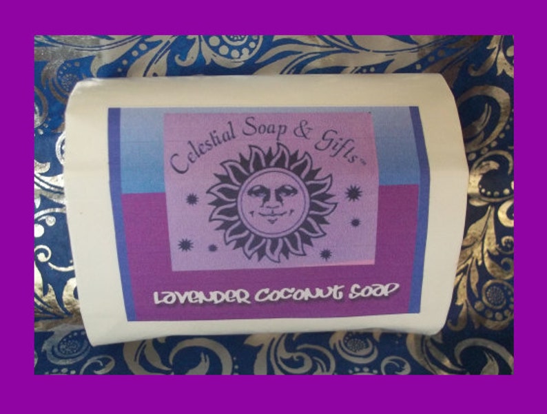 May include: A white rectangular soap bar with a purple, blue, and pink label. The label features a sun with a face and the text "Celestial Soap & Gifts" and "Lavender Coconut Soap".