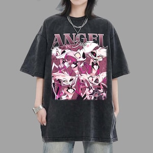 Puede incluir: Camiseta gris oscuro de gran tamaño con un gráfico de personajes de dibujos animados y el texto "ANGEL Dust" en rosa y morado. La camiseta tiene un aspecto vintage y desgastado.