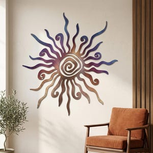 Peut inclure: Une décoration murale en forme de soleil avec un motif en spirale central entouré de nombreux rayons ondulés et rayonnants. La sculpture en métal présente un dégradé de couleurs, passant de tons cuivre et bronze chauds à des teintes violettes et bleues.